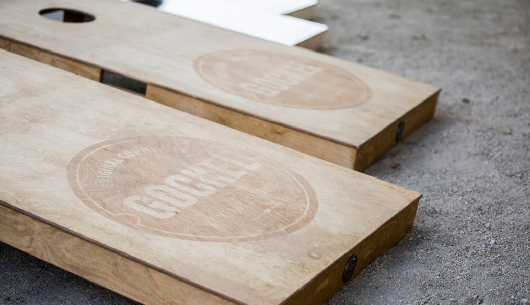 Traditional wooden cornhole board on grass.